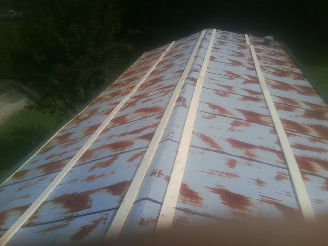 Rusted metal roof panels with new wood purlins before replacement — Storm Damage Roof Repair in Taftville by Roofing Brothers