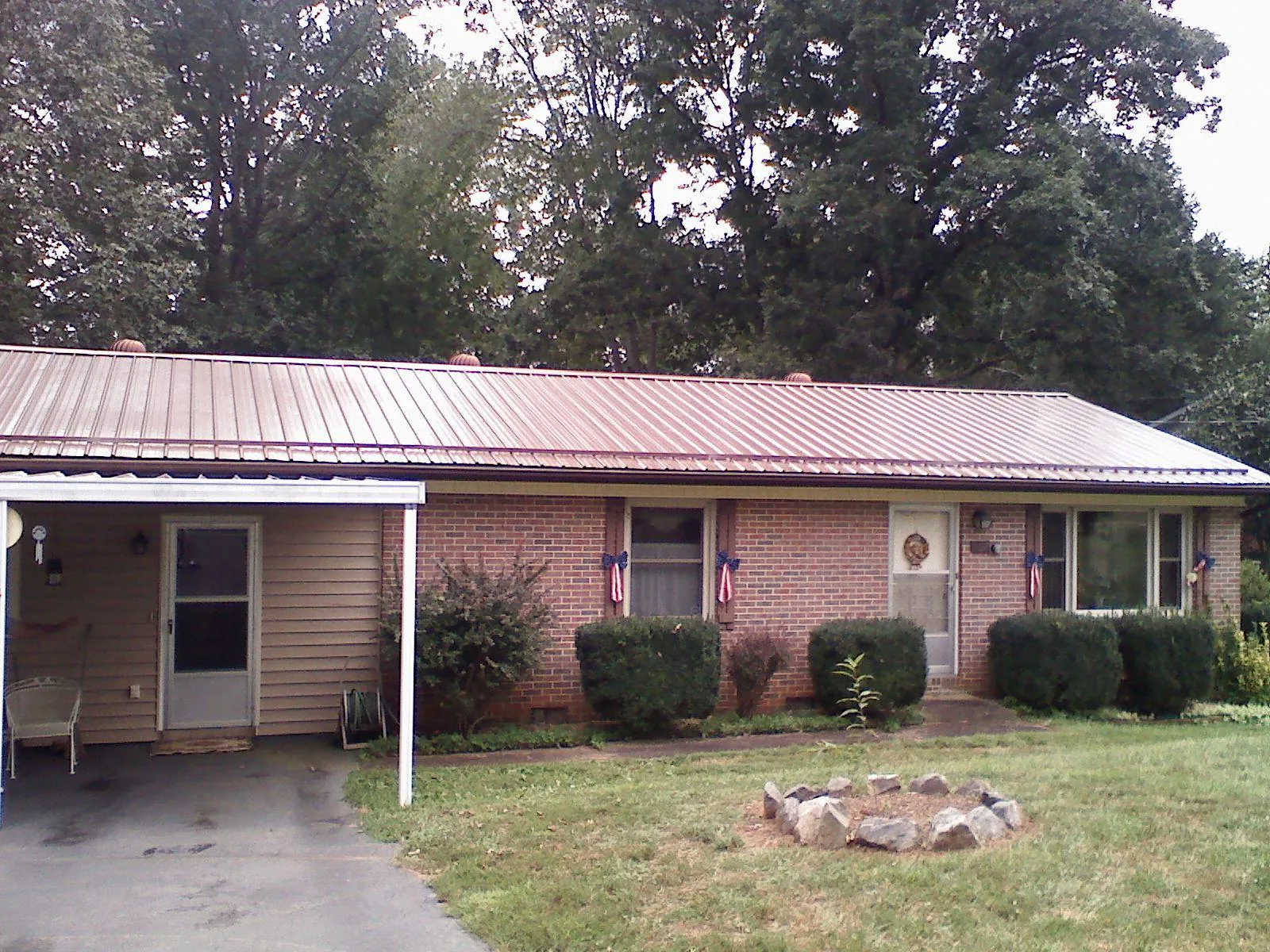 Bronze metal roof and carport on a brick ranch home — Roof Repair work by our crew in Taftville