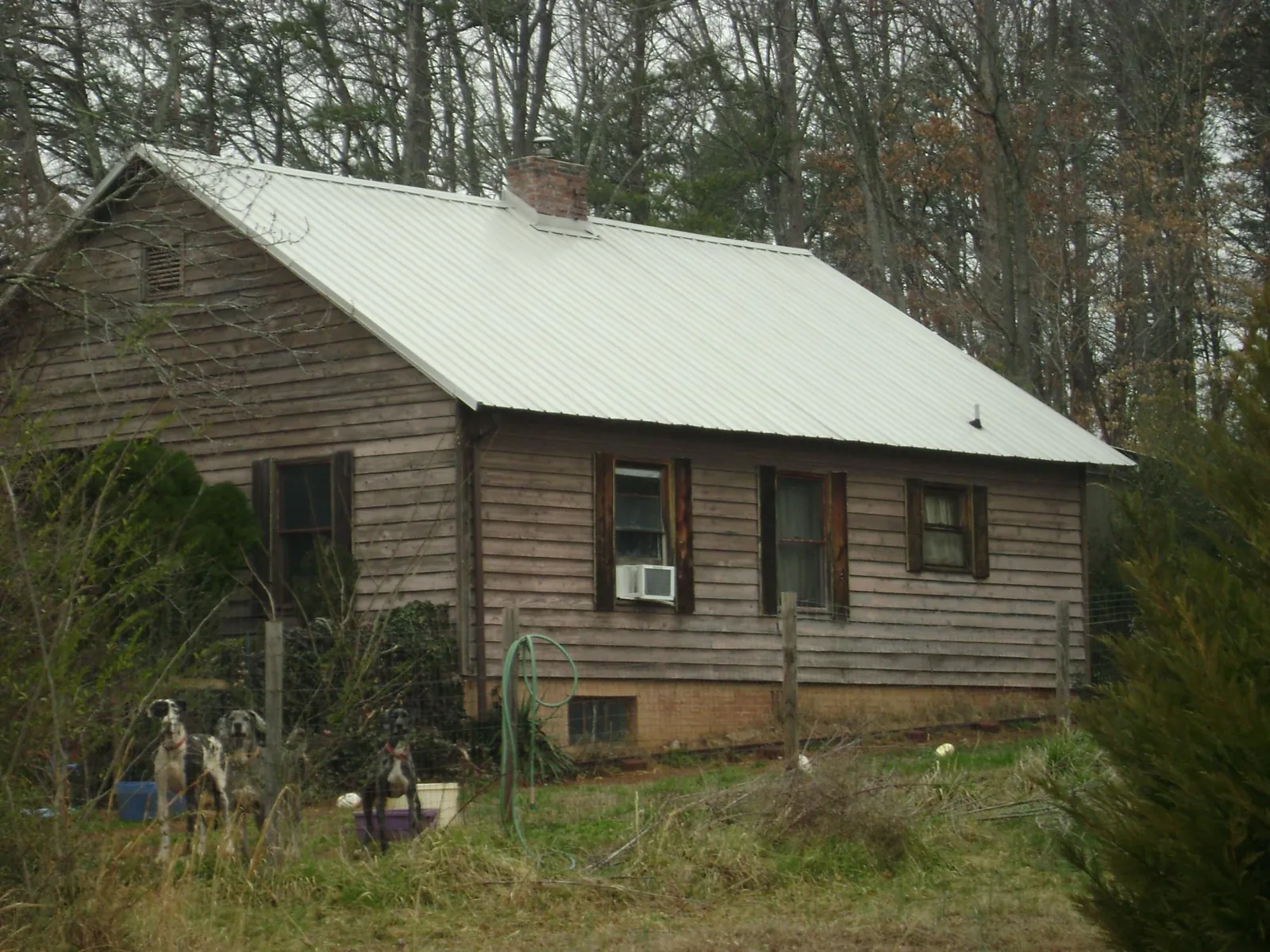White metal roof on an old wood sided farmhouse, from a Metal Roof Installation job in Taftville